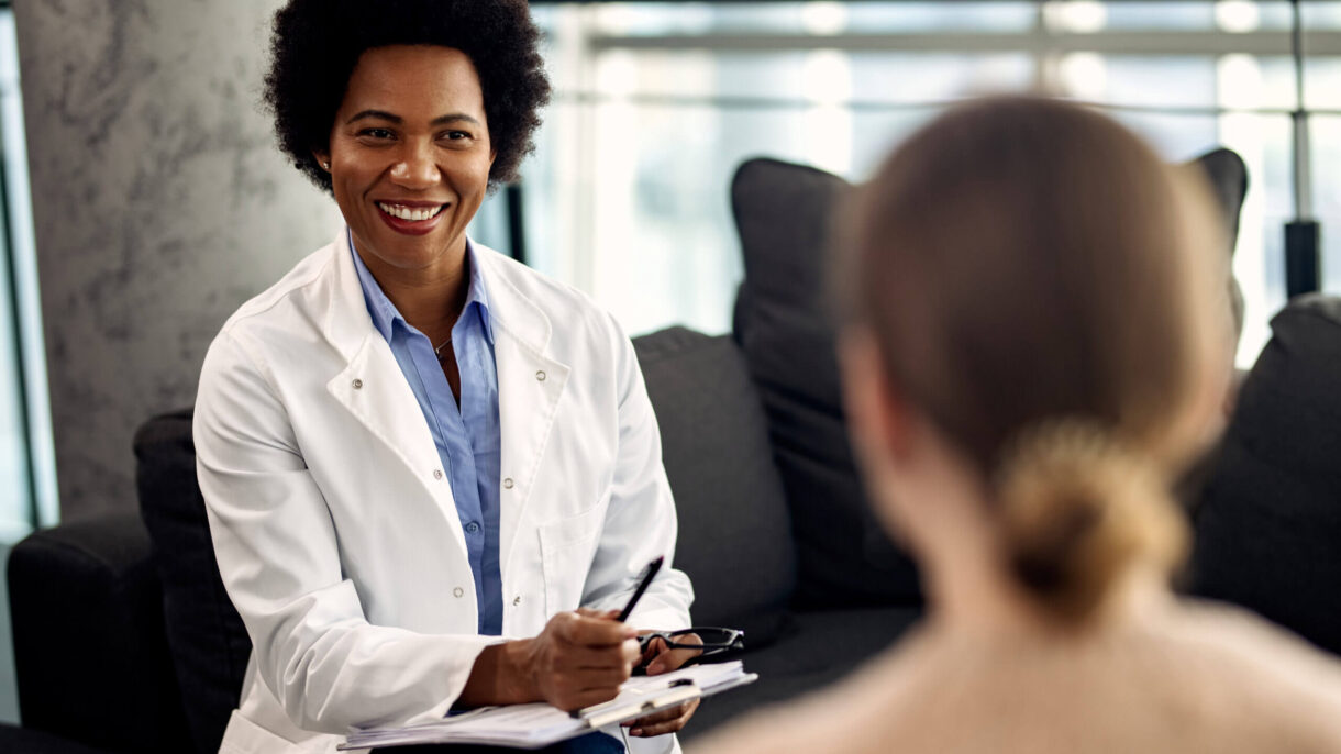 happy-african-american-doctor-talking-with-female-patient-psychotherapy-session-scaled (1)